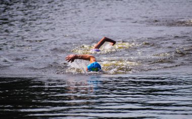 POLTAVA, UKRAINE - 19 Haziran 2021: Yüzücüler triatlon yarışmaları sırasında Vorskla Nehri boyunca yüzerler