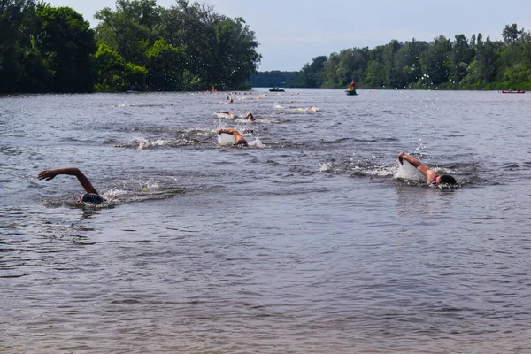 POLTAVA, UKRAINE - 19 Haziran 2021: Yüzücüler triatlon yarışmaları sırasında Vorskla Nehri boyunca yüzerler