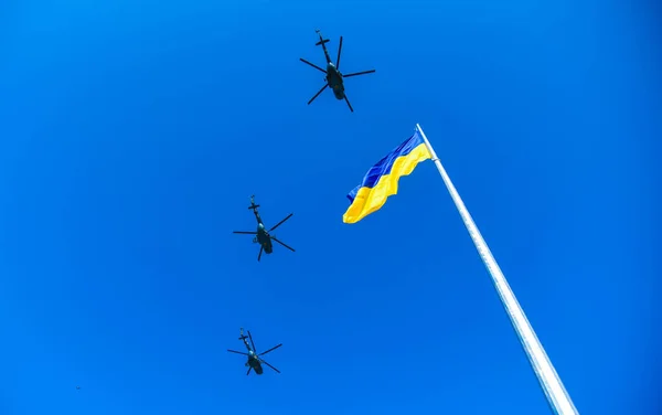 POLTAVA, UKRAINE - 23 Ağustos 2021: Yazın öğleden sonra mavi gökyüzünün arka planında Ukrayna ve Ukrayna askeri helikopterlerinin mavi ve sarı bayrağı