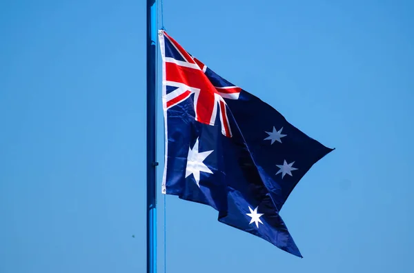 Avustralya bayrağı, İngiliz bayrağı ve altı beyaz yıldızı temsil eden dikdörtgen mavi bir bayrak.