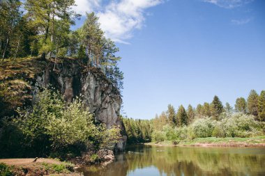 Nehirde asılı kaya, kayalık sahil, doğada huzur ve sessizlik, beyaz taş