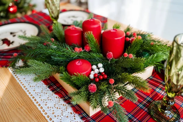 Yeni yıl masasının tasarımında kırmızı renk, masanın üzerinde bir Noel ağacı mumları masa örtüsü, bayram için masa örtüsü, yeni yıl masası