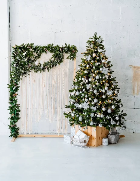 Oyuncak ve sarı ışıklarla süslenmiş Noel ağacı, apartmanın iç kısmında yeşil Noel ağacı, Noel ağacı dekoru, kış tatili konsepti