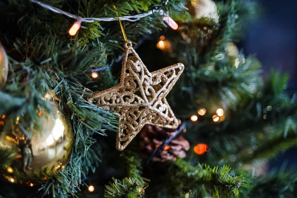 Noel ağacında altın yıldız, altın toplarla süslenmiş Noel ağacı çelengi, apartmanın içinde yeşil ladin, Noel tatili için hazırlık.