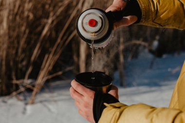 Termostan bir fincana çay dökmek, doğada sıcak çay içmek, yürüyüş yapmak, doğada yemek, kışın sıcak kahveyle ısınmak, çay demlemek.