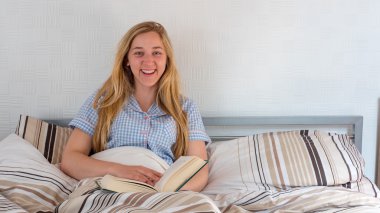 güzel kız yatakta yatarken kitap okuma