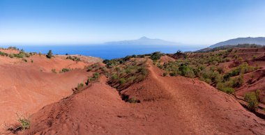 La Gomera, Agulo 'nun yukarısında Tenerife adası manzaralı kızıl toprak manzarasından Mirador de Abrante' ye doğru yürüyüş yapıyor.
