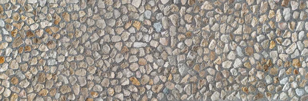 Element of an industrially manufactured stone wall made of many medium-sized natural stones in gray concrete