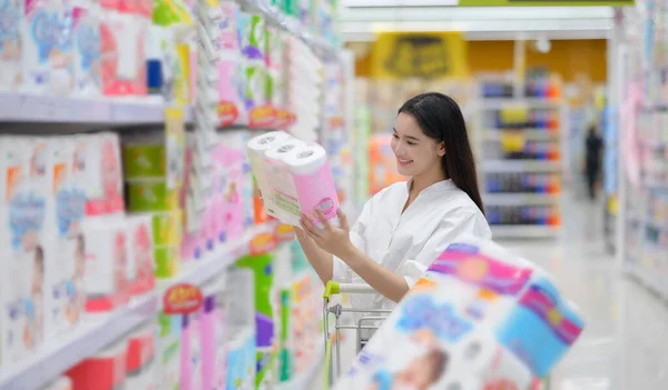 Gülümseyen mutlu kadın süpermarketten alışveriş yapıyor. Genç kadın süpermarketten alışveriş yapıyor.