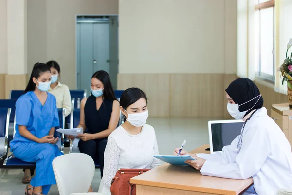 Many people wearing a surgical mask comes to the hospital for examination.