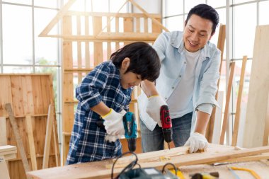 Asyalı baba ve oğlu evde marangozluk yapıyor..