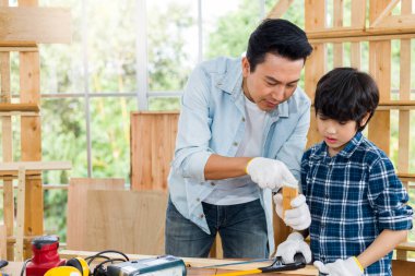 Asyalı baba oğluna evde marangozluk yapmayı öğretiyor..