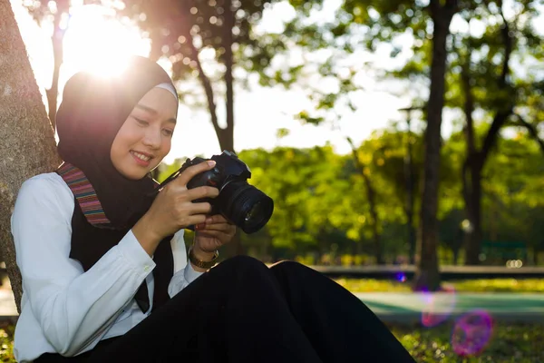 Asiatisk Muslimsk Kvinna Sitter Trädgård Och Tittar Sin Kamera Vid — Stockfoto