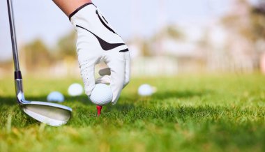 Golfçünün eli golf sahasında golf topuna vuruyor..