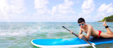 Üstsüz mayolu genç bir Asyalı güzel bulutlarla dolu açık bir günde denizde sörf yapıyor. Bir erkek turist yaz tatilini Koh Samet 'te dışarıda geçirir. Deniz doğası turu.
