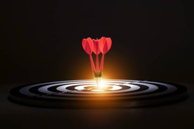 İş stratejisi ve hedefleri. Dartboard 'a turuncu ışıkla işlenmiş kırmızı oklar. Tam on ikiden..