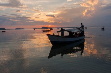 Andaman adalarının kıyısında teknelerle gün batımı