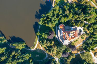 Göl ve orman tepeleriyle çevrili Trakoscan şatosunun hava manzarası, Hırvatistan kırsalında