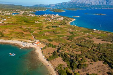 Hırvatistan 'ın Adriyatik Denizi kıyısındaki Korcula Adası' ndaki Lumbar kasabası yakınlarındaki plaj ve tarlaların hava manzarası