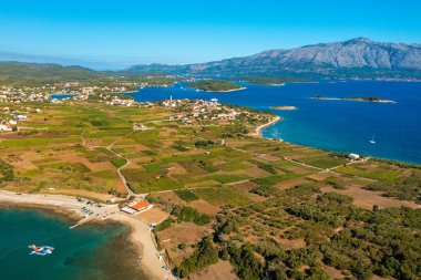 Hırvatistan 'ın Adriyatik Denizi kıyısındaki Korcula Adası' ndaki Lumbar kasabası yakınlarındaki plaj ve tarlaların hava manzarası