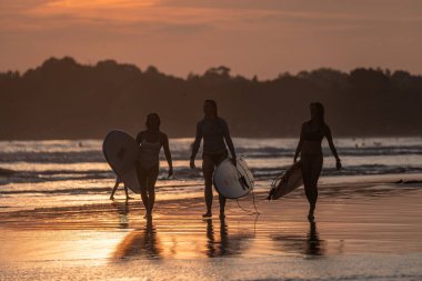 Gün batımında Sri Lanka sörfçüleriyle Weligama 'da halk plajı.
