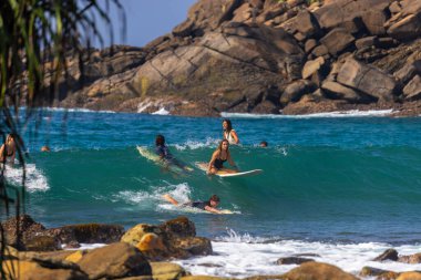Hiriketiya, Sri Lanka 'da Palmiye Ağaçları ve Turkuaz Okyanusu ile Rocky Tropikal Kıyı Şeridi yakınında Sörfçüler