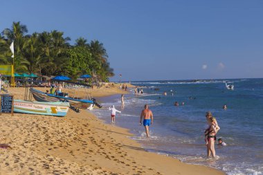 Unawatuna Plajı 'nda güneşli bir gün Sahilde yüzen Turistlerle, Sri Lanka