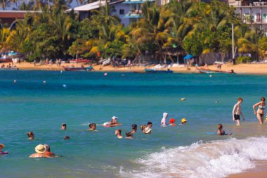 Unawatuna Plajı 'nda güneşli bir gün Sahilde yüzen Turistlerle, Sri Lanka