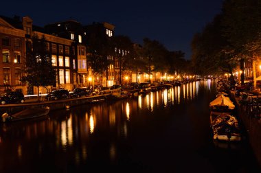 Bisikletler ve gece Amsterdam 'daki kanalda. Yaz.