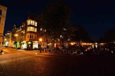 Bisikletler ve gece Amsterdam 'daki kanalda. Yaz.