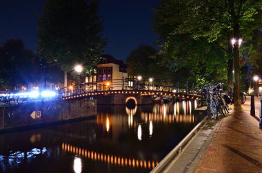 Bisikletler ve gece Amsterdam 'daki kanalda. Yaz.