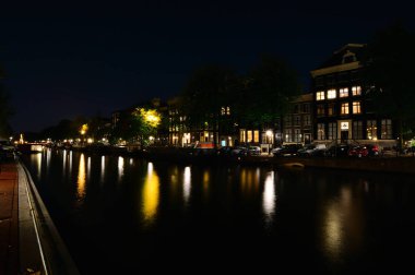 Bisikletler ve gece Amsterdam 'daki kanalda. Yaz.