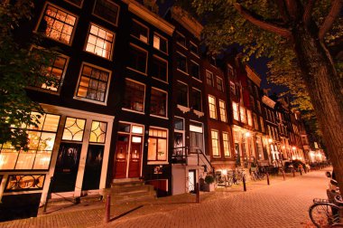 Amsterdam 'da gece, sokak lambalarının ışığında bisiklet ve caddeler. Gece. 