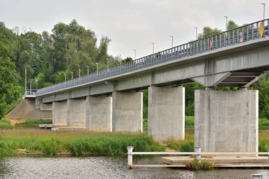 Bulutlu bir günde nehir üzerinde köprü. Yaz.