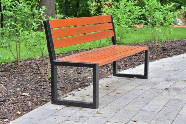 Ağaçların ve fenerlerin arasında park bankında. Yaz.