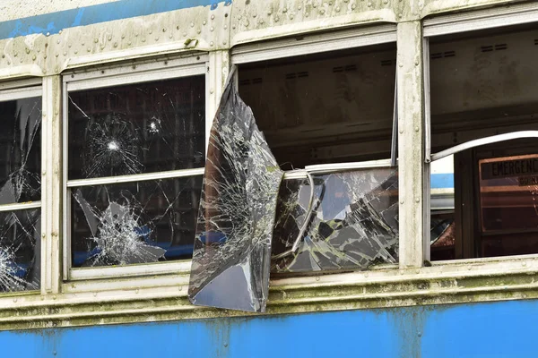 Uzak bir bölgede kırık camlı harap ve paslı bir otobüs.