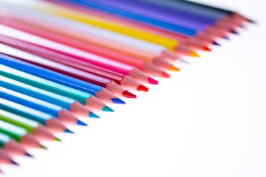 Beyaz arka planda 24 renkli boya kalemi, düzgün düzenlenmiş ve sivriltilmiş. Merhaba okul.