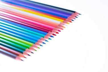 Beyaz arka planda 24 renkli boya kalemi, düzgün düzenlenmiş ve sivriltilmiş. Merhaba okul.