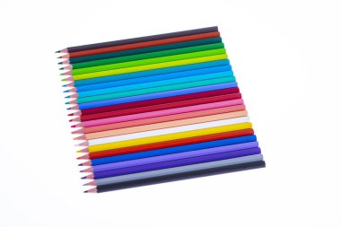 Beyaz arka planda 24 renkli boya kalemi, düzgün düzenlenmiş ve sivriltilmiş. Merhaba okul.