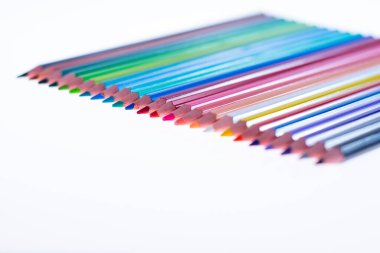 Beyaz arka planda 24 renkli boya kalemi, düzgün düzenlenmiş ve sivriltilmiş. Merhaba okul.