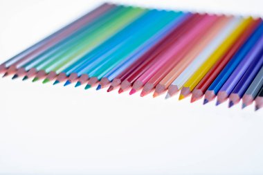 Beyaz arka planda 24 renkli boya kalemi, düzgün düzenlenmiş ve sivriltilmiş. Merhaba okul.