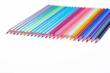 Beyaz arka planda 24 renkli boya kalemi, düzgün düzenlenmiş ve sivriltilmiş. Merhaba okul.