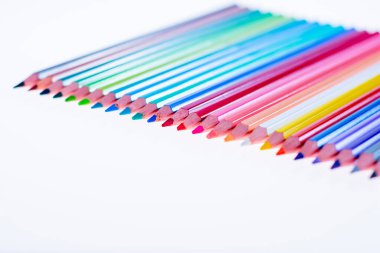 Beyaz arka planda 24 renkli boya kalemi, düzgün düzenlenmiş ve sivriltilmiş. Merhaba okul.