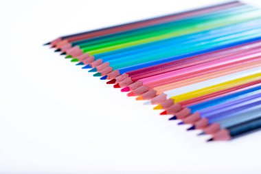 Beyaz arka planda 24 renkli boya kalemi, düzgün düzenlenmiş ve sivriltilmiş. Merhaba okul.