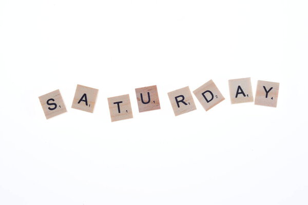 Word saturday arranged from wooden blocks on white background.