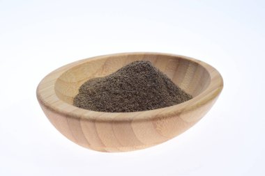 Ahşap bir kasede, beyaz bir arka plana karşı öğütülmüş biber. Yiyecek..