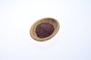 Tahta bir kasede bembeyaz bir zemine karşı keten tohumu. Yiyecek.. 