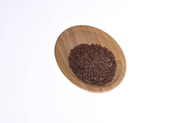 Tahta bir kasede bembeyaz bir zemine karşı keten tohumu. Yiyecek.. 