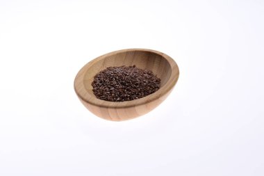 Tahta bir kasede bembeyaz bir zemine karşı keten tohumu. Yiyecek.. 