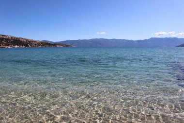 Adriyatik Denizi 'nin açık gök mavisi suları, aşağısı görünür, bir sonbahar günü güneşte küçük dalgalar, Krk Adası, Baska, Hırvatistan. 